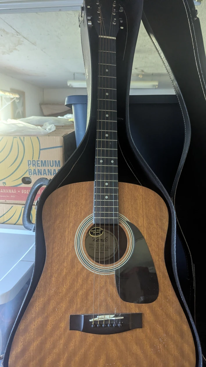 Acoustic guitar in a case, from the Angotti Estate listing